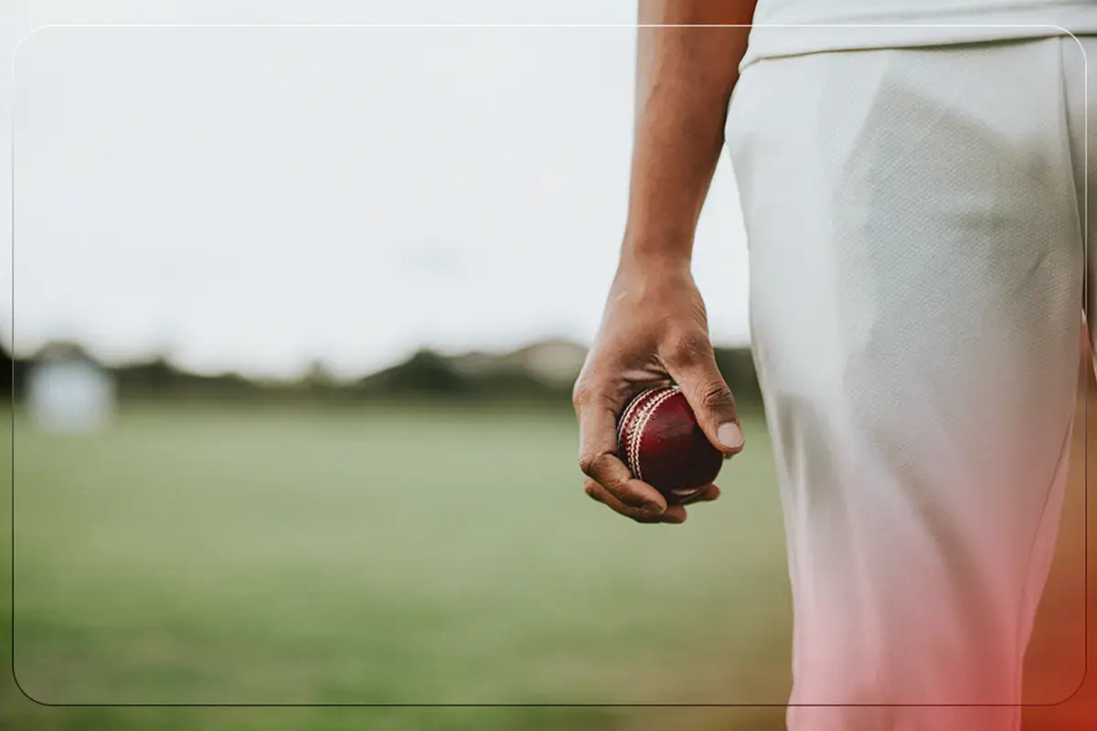 Cricketer holding a ball, demonstrating drills and techniques to improve bowling speed in cricket