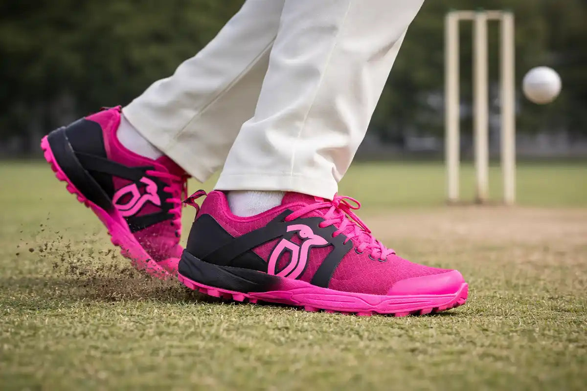 A cricket player wearing bright pink Kookaburra cricket shoes while moving on the pitch