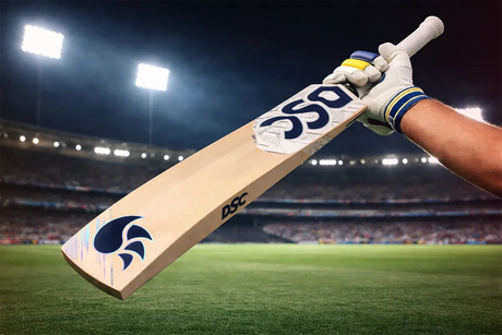 Professional cricketer holding a DSC cricket bat on a stadium field under floodlights, showcasing premium bat design